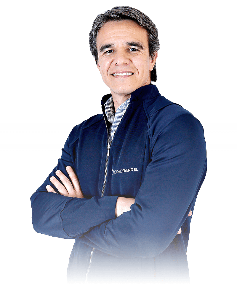 Dr. Rodrigo Wendel, cirurgião-dentista, em retrato de estúdio, sorrindo, de braços cruzados.